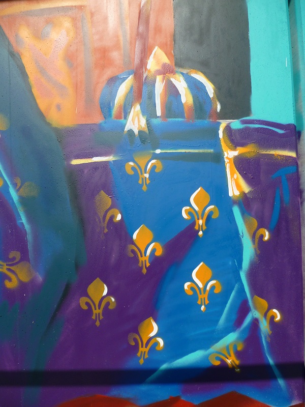 détail d'une fresque murale avec des fleurs de lys dorées sur un fond de tissu bleu et une couronne