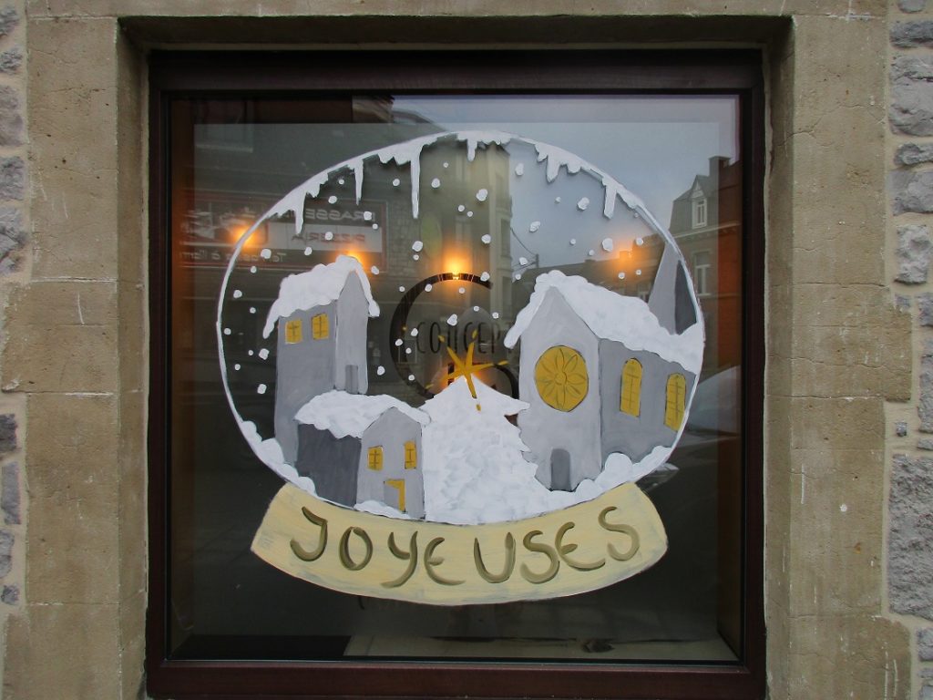 boule de noel peinte sur une vitrine avec maisons enneigées