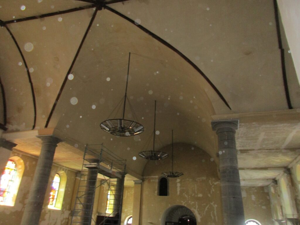 une église ne cours de restauration, il y a beaucoup de traces sur les murs, les vitraux apportent de la lumière